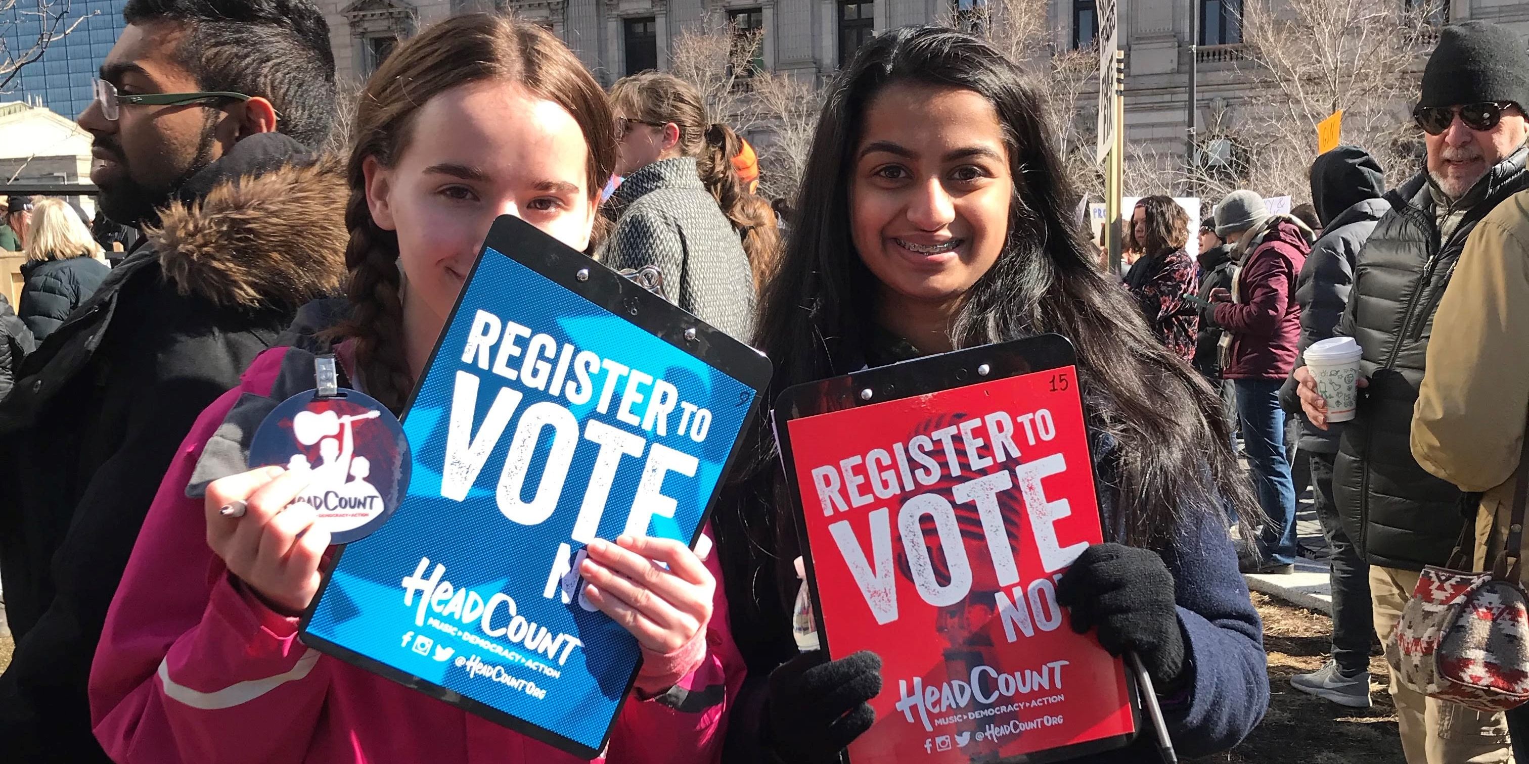 Two students holding signs that say register to vote